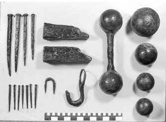 Iron objects extracted from concretion with the careful use of explosives. Note their undamaged condition. Scale in centimetres and inches.