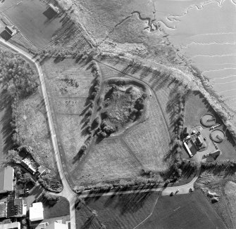 Oblique aerial view centred on the remains of the castle with Castle Mains house adjacent, taken from the NE.