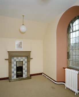 Interior, view of top floor South East room in side wing showing original stone fireplace with tiled insert