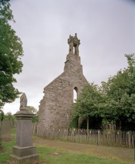 View from NW showing the ruined gable, belfry and churchyard.