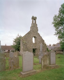 View from SE showing the ruined gable, belfry and churchyard.