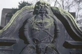 Detail of headstone showing Green Man with anchor in mouth and tools below, North Leith  Parish Churchyard, Edinburgh.