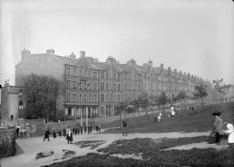 View of children and women in Holyrood Park, Edinburgh showing Royal Park Terrace in the background.