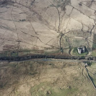 Oblique aerial view centred on the remains of the castle, chapel and moated site, taken from the S.