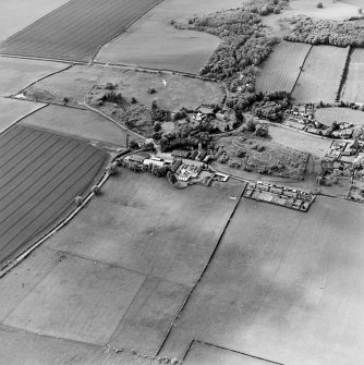 Oblique aerial view centred on the farmsteadings, church and burial ground with village adjacent, taken from the ESE