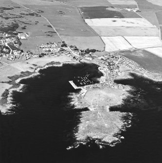 General oblique aerial view centred on the village, harbour, and the remains of the chapel and promontory fort, taken from the SSE.