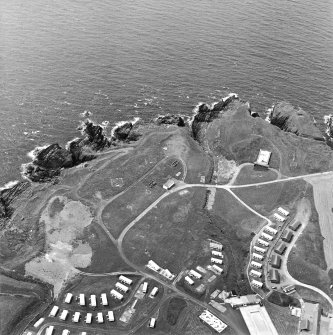 Oblique aerial view centred on the remains of the anti-aircraft battery and buildings with the remains of the promontory fort adjacent, taken from the NE.