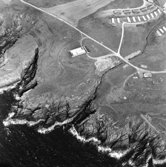 Oblique aerial view centred on the remains of the anti-aircraft battery and buildings with the remains of the promontory fort adjacent, taken from the S.