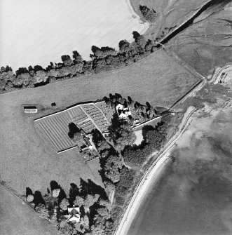 Oblique aerial view centred on the church, burial ground, farmsteading and barn with saltings adjacent, taken from the W.