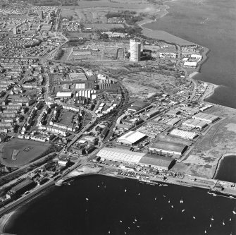 Oblique aerial view centred on the office and works with the harbour, industrial estate and gas works adjacent, taken from the E.