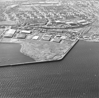 Oblique aerial view centred on the industrial estate with the office, works and harbour adjacent, taken from the N.