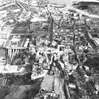 Aerial view of centre of Edinburgh including Castle Esplanade in foreground looking down High Street towards Holyrood Palace, with The Mound and National Gallery of Scotland on left of photograph and Old College and Chambers Street to right