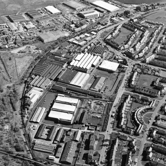 Oblique aerial view centred on the office and works with the industrial estate adjacent, taken from the SW.