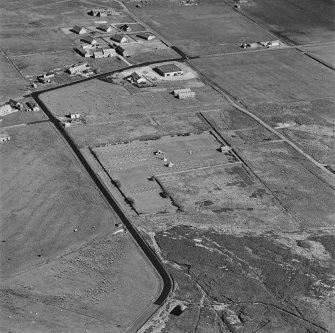 Oblique aerial view of Orkney, Hoy, Lyness, Royal Naval Oil terminal, view from NW, centred on Naval Cemetery and pillbox.
