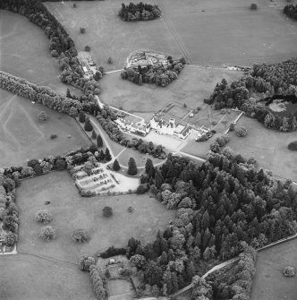 Oblique aerial view of Blair Castle centred on the country house and garden, with the remains of a church adjacent, taken from the NNE.