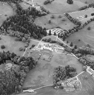 Oblique aerial view of Blair Castle centred on the country house and garden, with the remains of a church adjacent, taken from the SSW.
