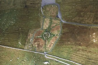 Oblique aerial view centred on the remains of the stone circle, stone alignments and chambered cairn, taken from the S.