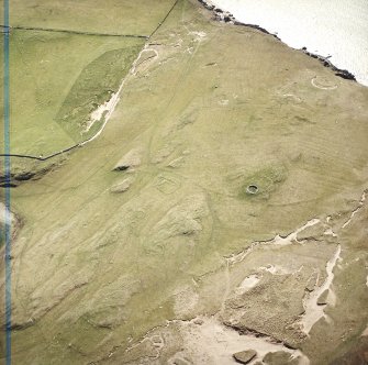 Oblique aerial view centred on the remains of the hut-circles, farmstead and rig with the farmstead adjacent, taken from the N.