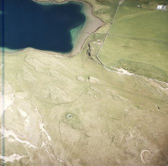 Oblique aerial view centred on the remains of the hut-circles, farmstead and rig with the farmstead adjacent, taken from the W.