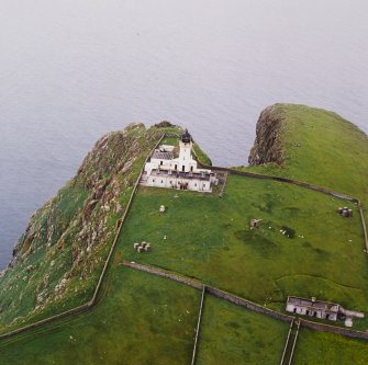 Oblique aerial view centred on the lighthouse with the remains of the dun adjacent, taken from the E.