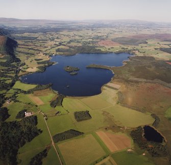 General oblique aerial view of the Lake of Menteith centred on the priory and crannog, taken from the WSW.