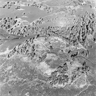 Oblique aerial view centred on the remains of the fort and possible cairn, taken from the S.