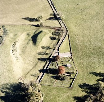 Oblique aerial view of Edzell, Castle Hillock centred on the remains of the Motte-and-bailey castle with church and burial ground adjacent, taken from the W.