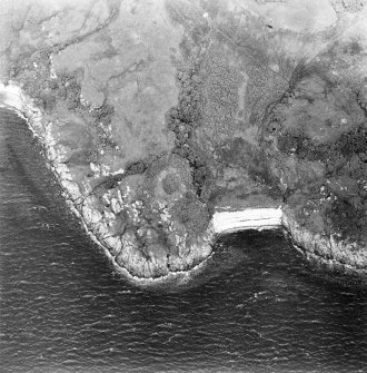 Oblique aerial view centred on the remains of the dun, taken from the SW.
