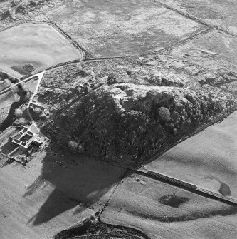 Oblique aerial view centred on the remains of the fort with the farmstead adjacent, taken from the N.