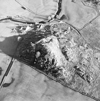 Oblique aerial view centred on the remains of the fort with the farmstead adjacent, taken from the W.