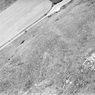 Oblique aerial view centred on the remains of the fort and cairn, taken from the SW.
