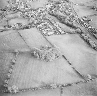 Oblique aerial view centred on the remains of the fort and rig with village adjacent, taken from the W.