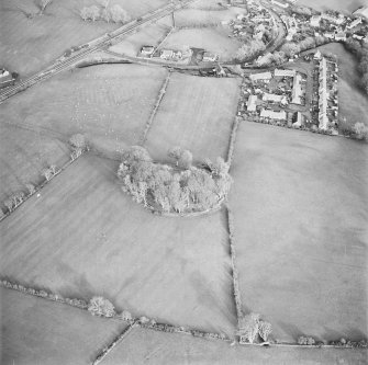Oblique aerial view centred on the remains of the fort and rig with village adjacent, taken from the WSW.
