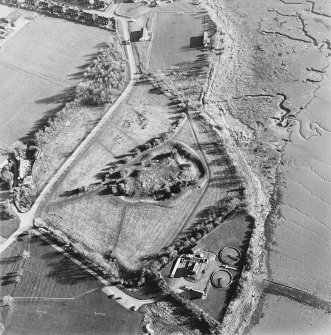 Oblique aerial view centred on the remains of the castle with Castle Mains house adjacent, taken from the NNW.