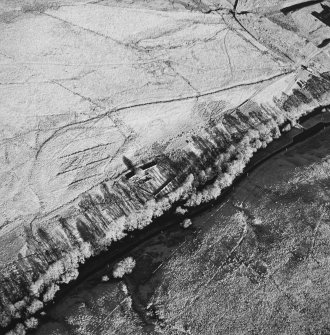 Oblique aerial view of Hermitage centred on the remains of a chapel, boundary dyke and moated site, taken from the SW.
