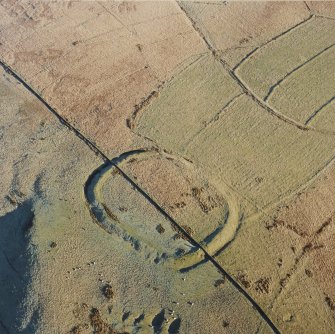 Oblique aerial view of Kirk Hill centred on the remains of a fort and palisaded enclosure with the remains of a farmstead, field-system, rig and boundary banks adjacent, taken from the W.