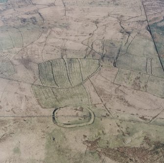 Oblique aerial view centred on the remains of the fort and palisaded enclosure, field-system, rig and boundary banks with enclosures, lazy beds, boundary ditches, field-system and rig adjacent, taken from the WNW.