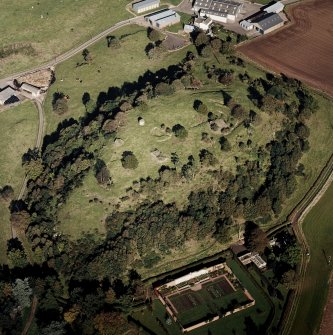 Oblique aerial view centred on the remains of the vitrified fort and broch, taken from the SSW.