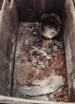 Excavation photographs: Contents of cist, detail of cremated bones in middle of cist; detail of Food Vessel Urn; general views of cist contents.