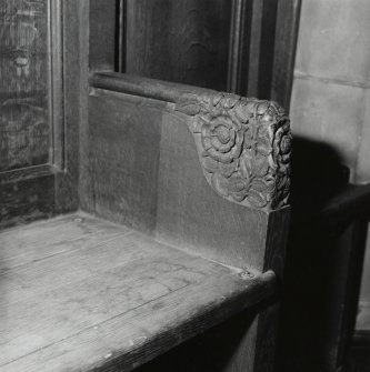 Interior, detail of platform woodwork showing foliated armrest