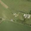 Oblique aerial view centred on the remains of the tower-house with the farmsteading adjacent, taken from the SW.
