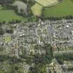 Oblique aerial view of the town centred on the church, chapel and parsonage, taken from the SW.
