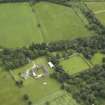 Oblique aerial view centred on the farmhouse, farmsteading and walled garden, taken from the NW.