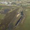 Oblique aerial view centred on railway marshalling yard showing area of former sidings on W side, taken from the SE.