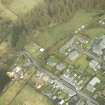 Oblique aerial view centred on station and level crossing site and the NW end of Langholm Street, taken from the S.