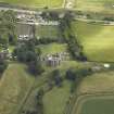 Oblique aerial view centred on the country house with the Collegiate Chapel adjacent, taken from the N.