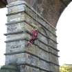 Detail, view from NE,  of drill operator abseiling whilst test drilling lower pier of viaduct.
