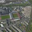 Oblique aerial view centred on the football stadium with the distillery adjacent, taken from the S.
