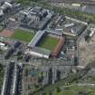 Oblique aerial view centred on the football stadium with the distillery adjacent, taken from the SE.