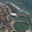 Oblique aerial view centred on the boathouse/boatshed with the harbour adjacent, taken from the W.